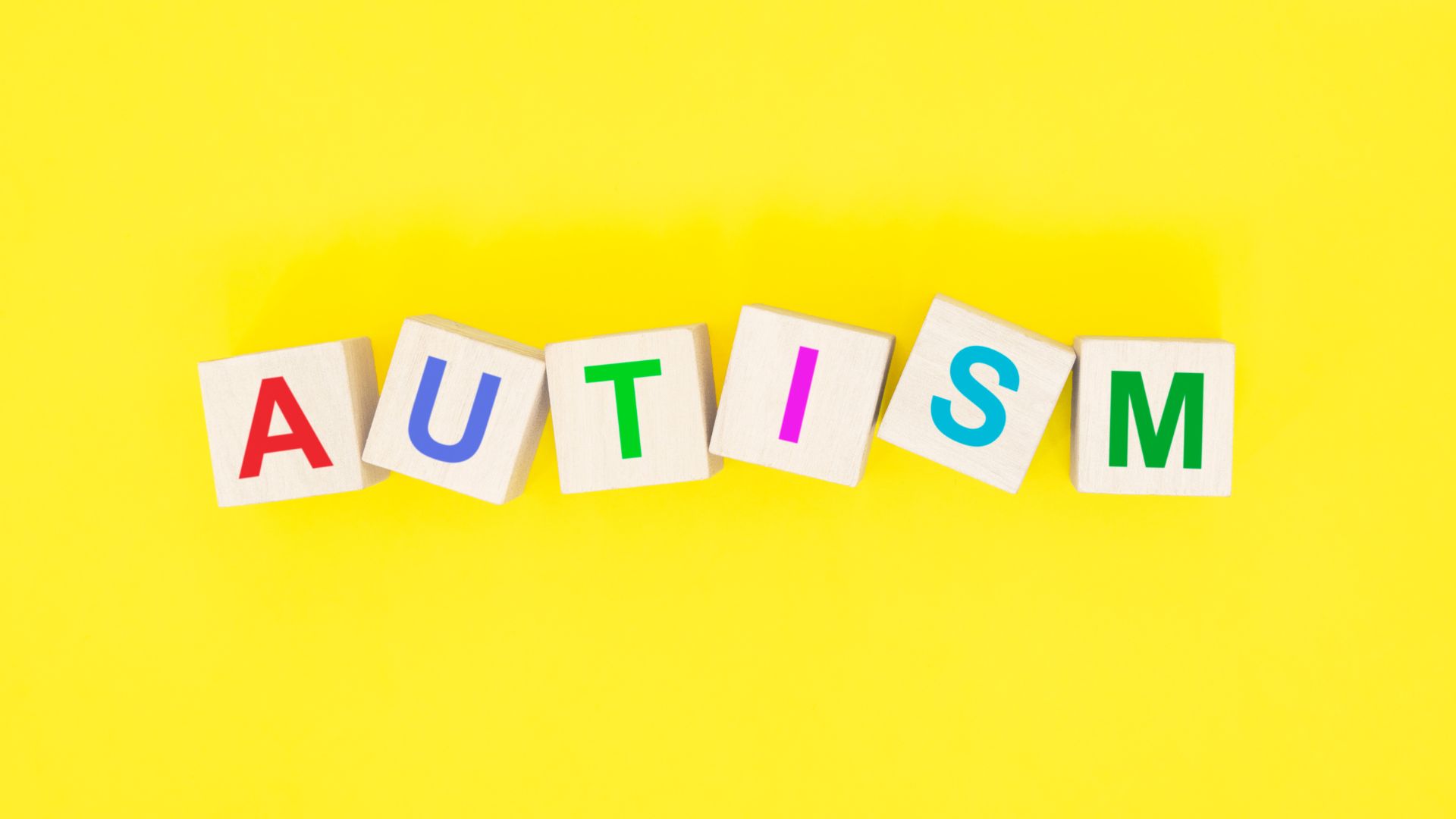 autism spelt out in blocks on a yellow background
